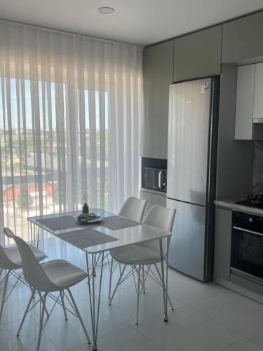 a kitchen with a table and chairs and a refrigerator at Bright Gray Нові затишні апартаменти біля центру in Ternopilʼ