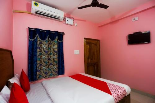 a bedroom with a bed and a ceiling fan at Hotel O Shriram Hotel in Puri