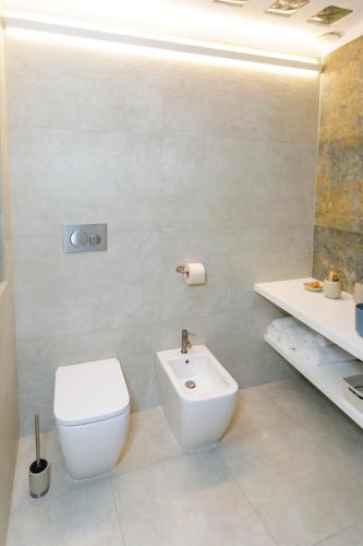 a bathroom with a white toilet and a sink at Lo Scirocco in Nardò