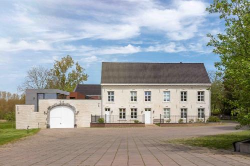 a large white building with a garage at Hof van Stayen in Sint-Truiden