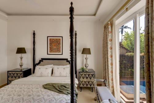 a bedroom with a bed and a large window at Trezora 2 Luxury 4BHK Villa with Pool in Assagaon in Goa
