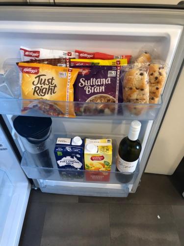 Villa Above Par, Cypress Lakes Resort, Premier 2 Storey Villa, 2 Bedrooms, both with Private Ensuites, Light Breakfast included في بوكولبين: ثلاجة مليئة بالأطعمة وغيرها من المواد الغذائية