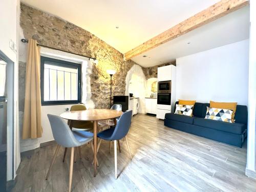 un salon avec une table, des chaises et un canapé dans l'établissement Studio Cocooning au coeur du Suquet, à Cannes
