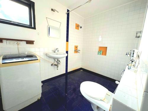 a bathroom with a toilet and a sink at Casa Tralia - 2 bhk duplex Apt in Nerul in Nerul