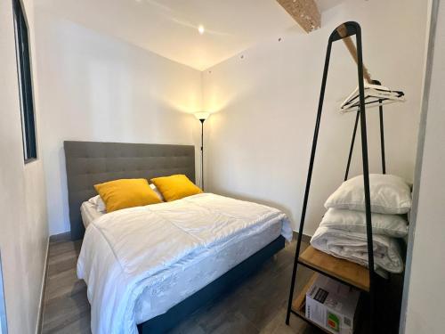 une chambre avec un lit avec des oreillers jaunes dans l'établissement Studio Cocooning au coeur du Suquet, à Cannes