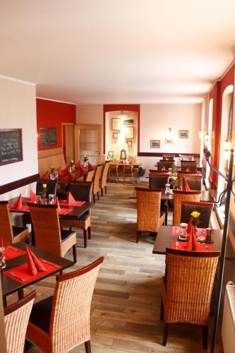 a restaurant with tables and chairs with red napkins at Landhaus Hammoor Stieper Gastronomie GmbH in Hammoor