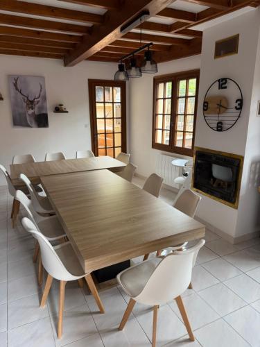 une table et des chaises en bois dans une pièce avec une cheminée dans l'établissement GITE 15 Places avec Jacuzzi à BOUTX LE MOURTIS, à Boutx