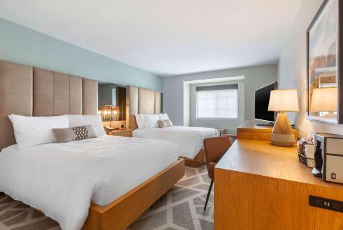 a hotel room with two beds and a television at La Quinta Inn & Suites by Wyndham Tempe University, Phoenix in Tempe
