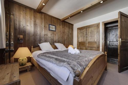 - une chambre avec un grand lit et des murs en bois dans l'établissement Résidence Combe Folle - Appartement spacieux · Balcon · Wifi MAE-9561, à Tignes