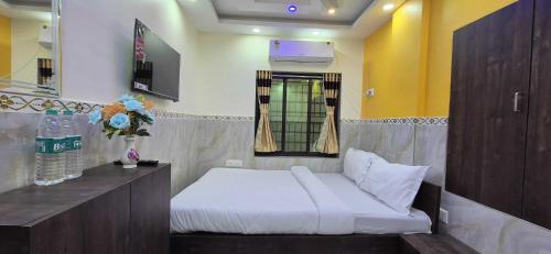 a bedroom with a white bed and a window at Hotel O Kalikapur Haltu in Kolkata