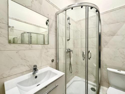 a bathroom with a sink and a shower at Pokoje na Monte Cassino 26 in Sopot