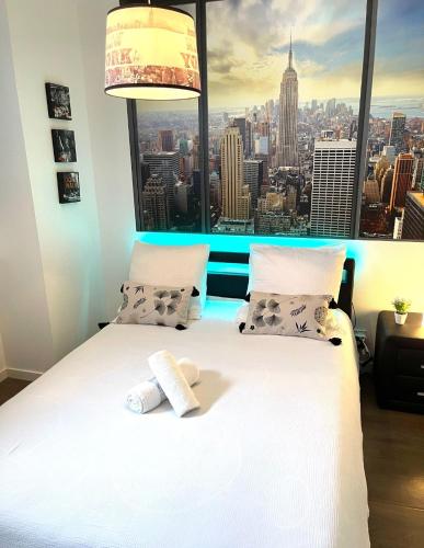 une chambre avec un lit blanc et une grande fenêtre dans l'établissement Le rivage du petit serein Vannes, à Vannes