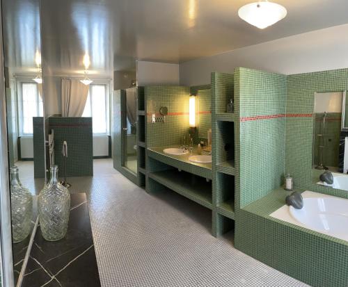 a green bathroom with two sinks and a tub at L'Auberge du Château in Tilloloy