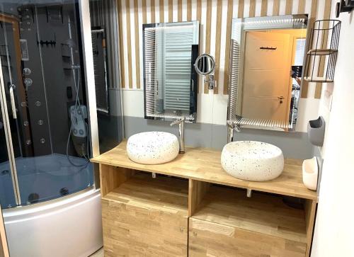 une salle de bain avec deux lavabos et une douche dans l'établissement Le rivage du petit serein Vannes, à Vannes