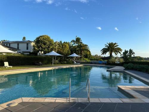 a large swimming pool in a yard with trees at Luxury 3BR, 2BA Unit with Pool & BBQ in Gold Coast in Gold Coast