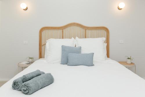 a white bed with pillows and towels on it at Hinterland hideaway in Maroochy River