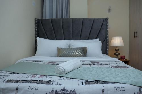 a bedroom with a large bed with a black headboard at The Nordic Nest in Ruiru