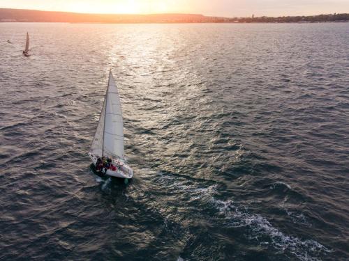 a small sail boat in the water at sunset at seeglueck OASE - Charmante Unterkunft mit Garten Gästezimmern und Tiny House nahe Universität Insel Mainau und See in Konstanz in Konstanz