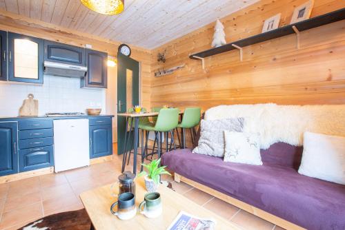 Il comprend un salon avec un canapé violet et une cuisine. dans l'établissement Great value simple studio, à Morzine