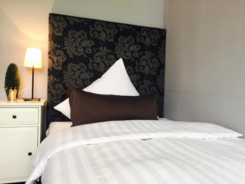 a bedroom with a bed with a black and white comforter at Hotel Heddernheimer Hof in Frankfurt/Main