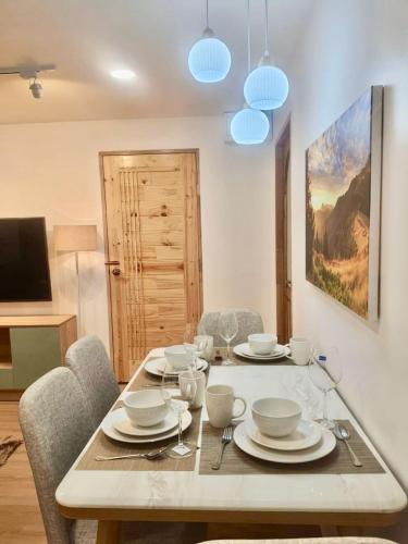 a dining room with a table with plates and bowls at 103 Condominium 2, 2 bedroom in Chiang Mai
