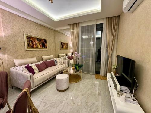 Una sala de estar con un sofá y un televisor. en Cleopatra Beach Luxury, en Alanya