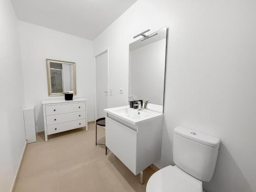 a white bathroom with a toilet and a sink at Studio lumineux avec balcon privé in Poissy