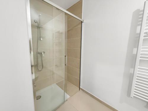 a bathroom with a shower with a glass door at Studio lumineux avec balcon privé in Poissy