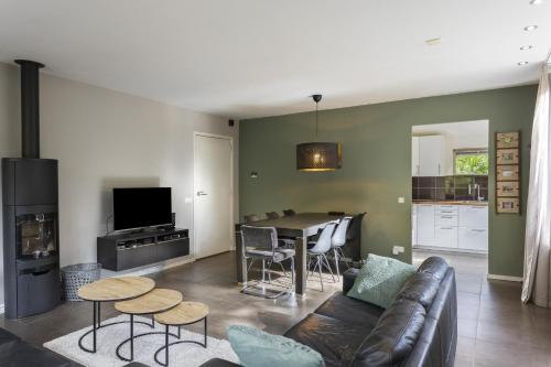 a living room with a couch and a table at Relaxen in het bos met privésauna in Holten