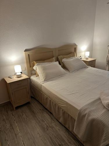 a bedroom with a large bed with two lamps on tables at Spiti Skiathos town in Skiathos