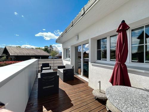 a large red umbrella sitting on a wooden deck at Le Petit Bonheur in Salavaux