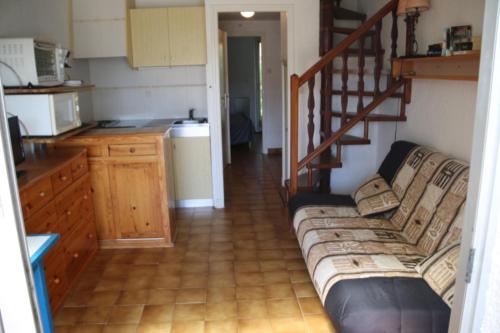 un salon avec un canapé et une cuisine dans l'établissement Villa 113, Heliovillage au village naturiste, au Cap d'Agde