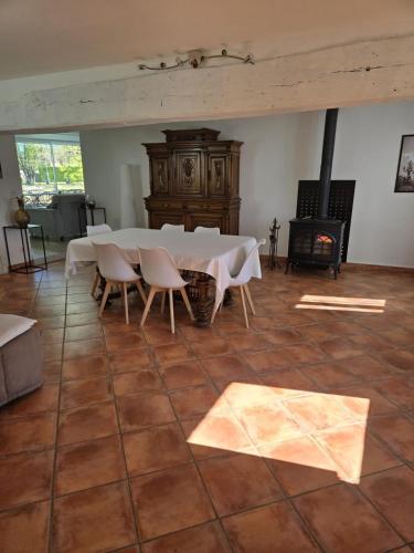 une pièce avec une table, des chaises et une cheminée dans l'établissement Chez Julienne - Mur de Sologne - 6 personnes, à Mur-de-Sologne