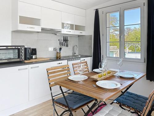 a kitchen with a wooden table with two chairs and a tableasteryasteryasteryastery at Le Petit Bonheur in Salavaux