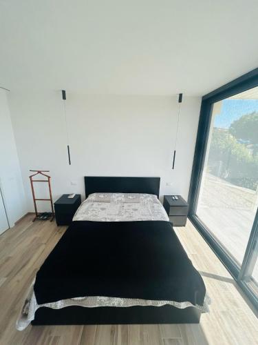 a bedroom with a bed and a large window at La casa dell'orto in Imperia