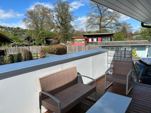 a patio with two chairs on a white wall at Le Petit Bonheur in Salavaux
