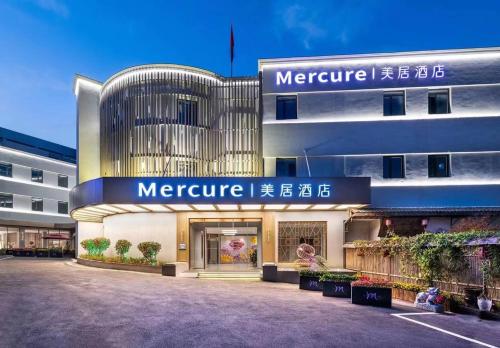 a large building with a sign that reads mercure at Mercure Qingdao Downtown in Qingdao