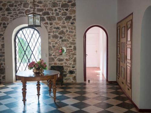 a hallway with a table and a stone wall at The Villa Averoff in Kírinthos