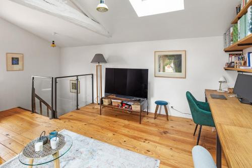 a living room with a television and a table at La Petite Fouques - Confortable et paisible in Cugand