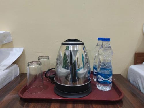 a coffee maker and two bottles of water on a table at BS Hotel & Restaurant in Chandrāpuri