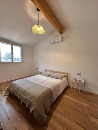 une chambre avec un grand lit et une lampe dans l'établissement Maison Calista, à Lanton