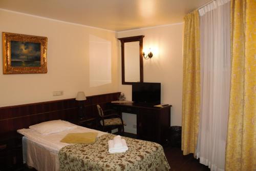 a hotel room with a bed and a television at Taanilinna Hotell in Tallinn