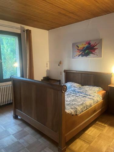 a bedroom with a bed with a wooden headboard at La chambre en bois de chez Antoine in Montpellier