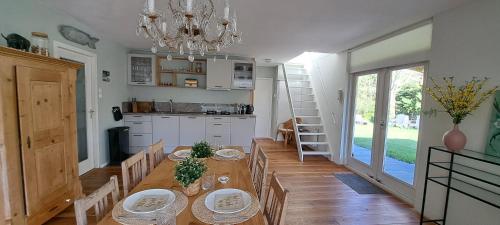 a dining room with a table and a chandelier at Vakantiehuis met sauna, omheinde tuin & nabij strand VP087 in Bruinisse