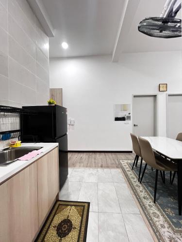 a kitchen with a table and a black refrigerator at Homely Stay by MySky Stays at Presint 5, Putrajaya in Putrajaya