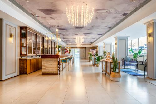 a lobby with a bar and tables and chairs at Mercure Qingdao Downtown in Qingdao