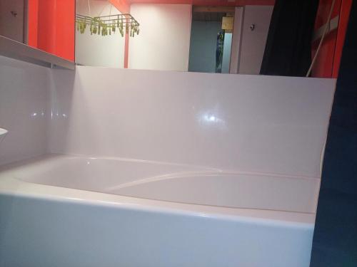 - une baignoire blanche dans une chambre avec miroir dans l'établissement Résidence Aiguille Grive 1 - Appartement duplex · Proche des pistes · Balcon MAE-2871, à Arc 1800