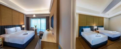 a hotel room with two beds and a desk at Swiss-Garden Beach Resort, Kuantan in Kuantan