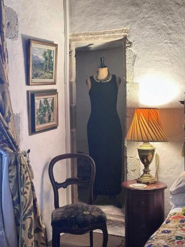 a dress on a mannequin in a doorway next to a chair at Chateau Mareuil in Brigueuil-le-Chantre