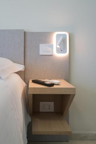 a bedside table with a remote control and an alarm clock at Relais Villa Ottavia in Bitonto